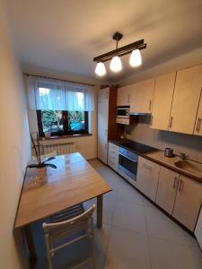 a kitchen with a wooden table and a counter top at Bronowice- parter domu in Kraków