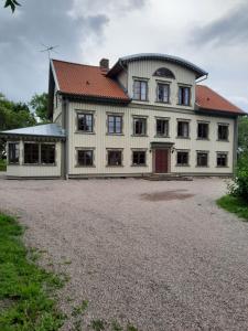 Sjötorps Säteris 1600-tals Huvudbyggnad في Larv: بيت ابيض كبير بسقف احمر