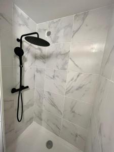 W łazience znajduje się prysznic ze ścianami z białego marmuru. w obiekcie Le Central : Appartement cosy et calme w mieście Saint-Germain-de-Joux