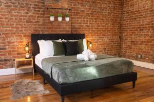 a bedroom with a large bed with a brick wall at Stunning Loft in the heart of OTR in Cincinnati