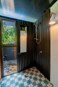 a bathroom with a shower and a mirror on the wall at Tiny garden house in Turrialba