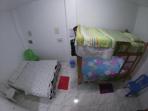 a small bedroom with two bunk beds and a tiled floor at Nanasqa Hostel en Nasca / Nazca in Nazca