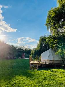 Una tienda de campaña sentada en un banco en un campo en WINE ROAD GLAMPING, en Cuvin
