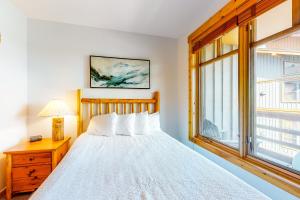 a bedroom with a white bed and a window at Tucker Mountain Lodge 307 in Copper Mountain