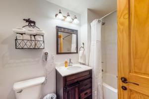 a bathroom with a sink and a toilet and a mirror at Tucker Mountain Lodge 307 in Copper Mountain +17 photos