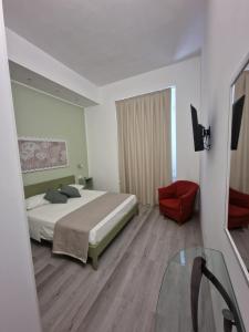 um quarto com uma cama e uma cadeira vermelha em La Presentosa Bed&Breakfast em Ortona