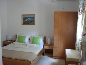 a bedroom with a bed with green pillows and a cabinet at La Santre Villa in Amoudara Herakliou