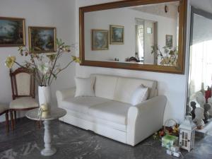 a living room with a white couch and a mirror at La Santre Villa in Amoudara Herakliou