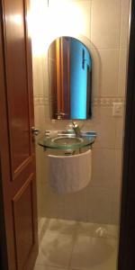 ein Bad mit einem Waschbecken und einem Spiegel in der Unterkunft Apartamento Bicho do Mar in Torres