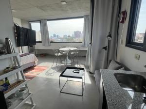 una sala de estar con mesa y una habitación con ventana en Hermoso Loft cerca de todo en Remedios de Escalada