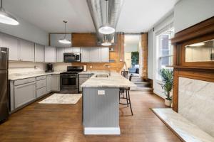 uma cozinha com electrodomésticos em aço inoxidável e pisos em madeira em City Escape 2BR Steps to TQL near OTR and Downtown em Cincinnati