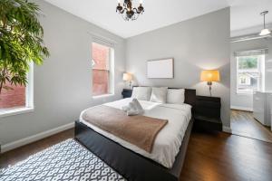 a bedroom with a large bed and a chandelier at City Escape 2BR Steps to TQL near OTR and Downtown in Cincinnati