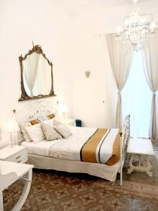 a bedroom with a bed with a mirror and a chandelier at B&b Morosoli Palace in Catania