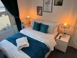ein Schlafzimmer mit einem weißen Bett mit blauen Kissen in der Unterkunft Luxury 1Bed Holiday Flat-10 Minutes from London Bridge & 3Mins walk to Lewisham DLR in London