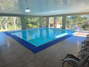 una gran piscina con suelo azul y ventanas en Lagoa Parque Hotel, en Lagoa Vermelha