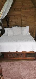 a bed with white sheets and pillows in a room at Glamping Villa Gilma in Sevilla