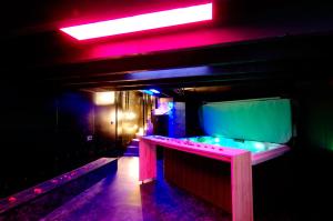 a dark room with a table and a red light at Mieuxqualhotel jacuzzi privatif La retro in Bordeaux