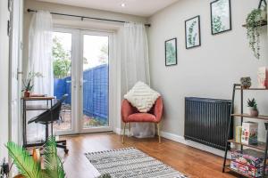 a living room with a chair and a sliding glass door at Private driveway - close to Warwick Racecourse & Warwick Castle!! in Warwick