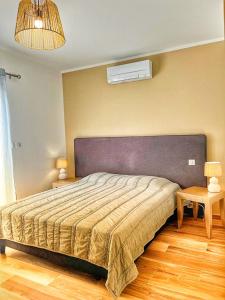 1 dormitorio con 1 cama, 2 mesas y ventilador en A PIAZZOLA en Petreto-Bicchisano