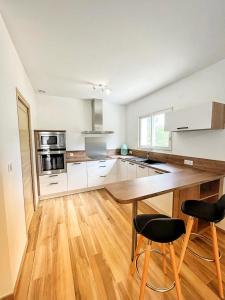 a kitchen with a wooden table and two chairs at A PIAZZOLA in Petreto-Bicchisano +20 photos