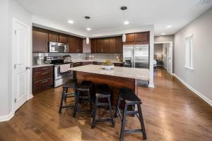 a kitchen with a large island with stools at Comfortable 2BR Condo near City Center in Cincinnati