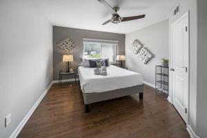 een slaapkamer met een bed en een plafondventilator bij Comfortable 2BR Condo near City Center in Cincinnati