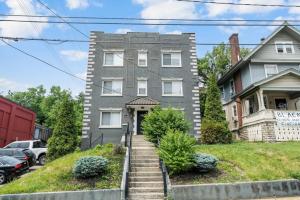 a gray house with stairs in front of it at Comfortable 2BR Condo near City Center in Cincinnati
