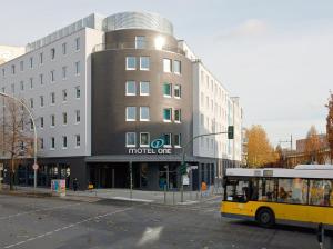 einem gelben Bus, der vor einem Gebäude parkt in der Unterkunft Motel One Berlin-Bellevue in Berlin