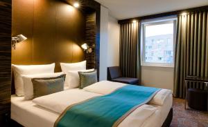 ein Hotelzimmer mit einem großen Bett und einem Fenster in der Unterkunft Motel One Berlin-Bellevue in Berlin