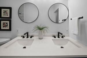 un baño con dos lavabos y dos espejos en Spacious and Modern 3BR near Downtown and Walnut Hills, en Cincinnati 27 fotos más