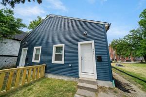 niebieski dom z białymi drzwiami i płotem w obiekcie Spacious and Modern 3BR near Downtown and Walnut Hills w mieście Cincinnati