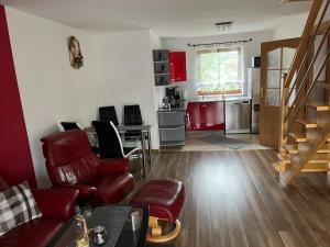 a living room with red furniture and a kitchen at Apartament u Jarosza in Poronin