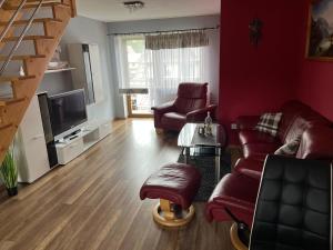 a living room with a couch and chairs and a television at Apartament u Jarosza in Poronin