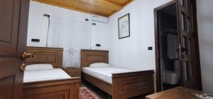 twee bedden in een kamer met een deur open bij Hazmurat Hotel in Gjirokastër