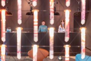 a man and a woman sitting behind a table with candles at Motel One Berlin-Spittelmarkt in Berlin