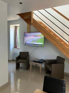 sala de estar con TV de pantalla plana en la pared en Bien être à la campagne, en Le Mesnil-Amand