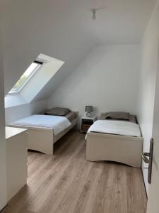 2 camas en una habitación blanca con ventana en Bien être à la campagne, en Le Mesnil-Amand