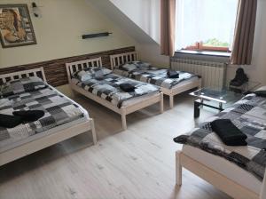 a room with three beds and a window at A-Piramida in Wrocław +10 photos