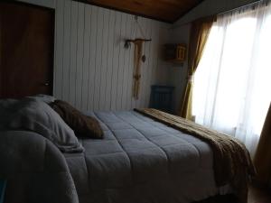 1 dormitorio con cama y ventana en Aldea Bahiguana, en Bahía Inglesa