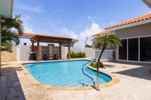 uma piscina com um gazebo ao lado de uma casa em Esmeralda 126 em Palm-Eagle Beach