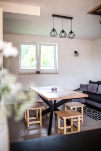 a living room with a table and two benches at Domki Lux Gródek nad Dunajcem in Gródek Nad Dunajcem