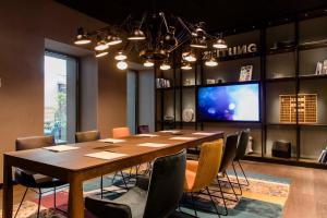 a conference room with a large wooden table and chairs at Motel One Hannover-Oper in Hannover