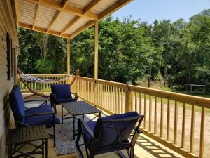 a porch with chairs and a hammock on it at Tiny home with hammock loft BBQ and yard in Phenix City