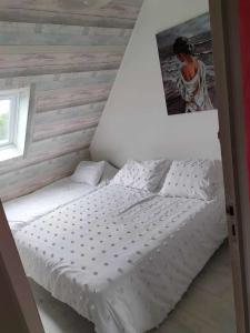a bed in a room with a wooden wall at la maison de marie in Ferques