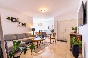 ein Wohnzimmer mit einem Sofa und einem Tisch in der Unterkunft Felicidad 30 in Oranjestad