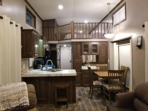 a kitchen with a sink and a table with chairs at Tiny home with hammock loft BBQ and yard in Phenix City