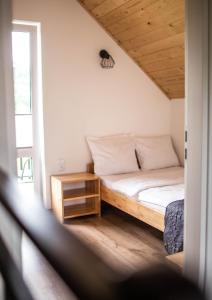 Dormitorio pequeño con cama y mesa en Domki Lux Gródek nad Dunajcem, en Gródek Nad Dunajcem