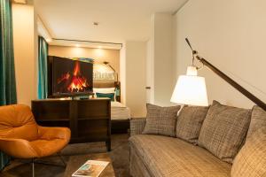 a living room with a couch and a tv at Motel One Bonn-Beethoven in Bonn