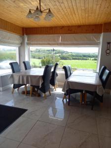 a dining room with a table and chairs and a large window at Teach na Coille B&B in Midleton