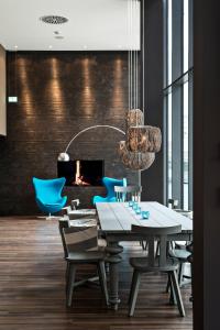 a dining room with a table and chairs and a fireplace at Motel One Bremen in Bremen
